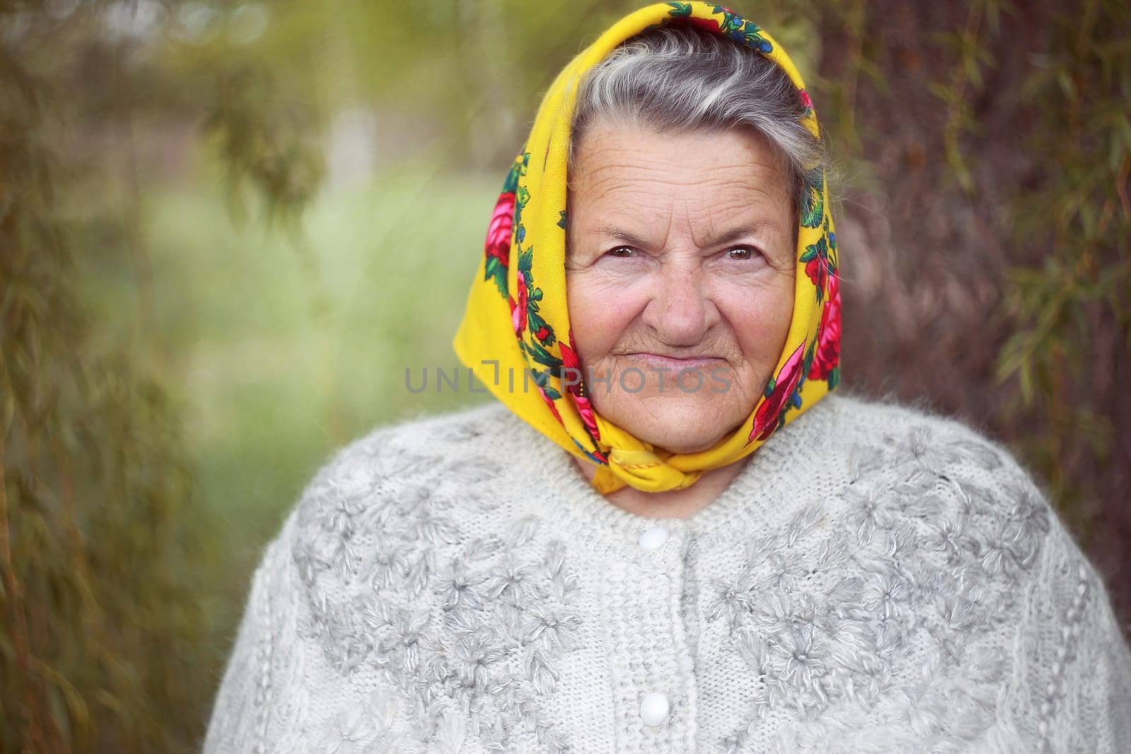 Close up portrait of a senior woman in a garden. Very old lady of eighty years old outdoor in summer. High quality photo