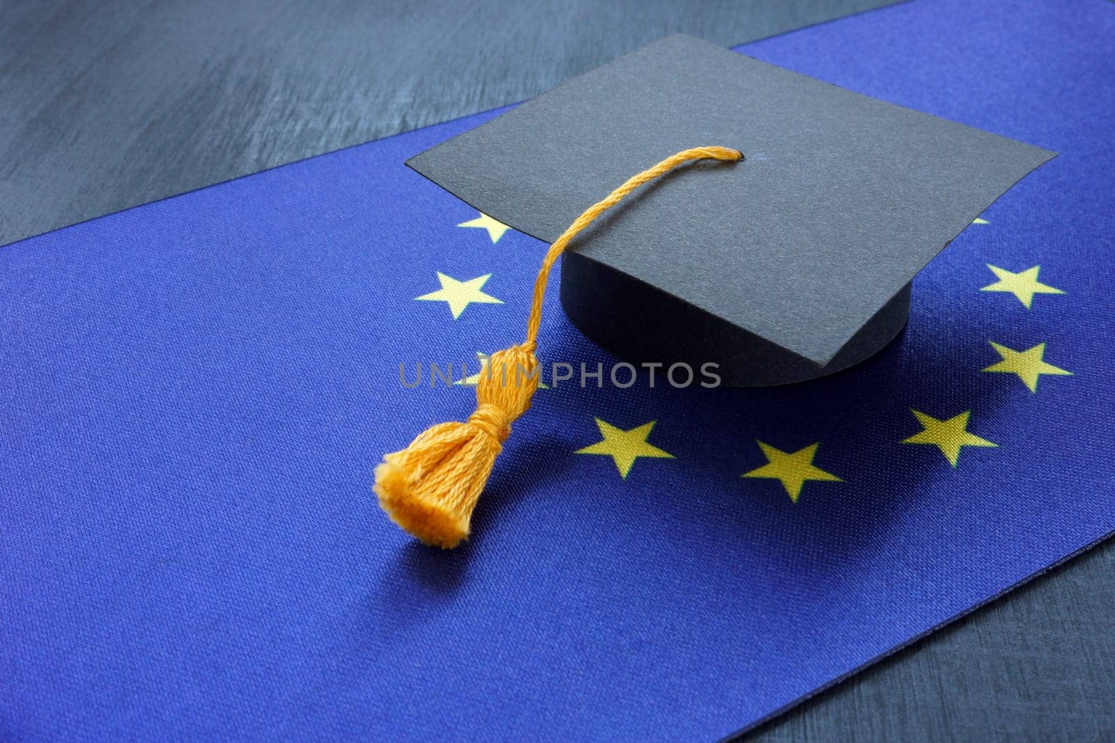 The flag of the European Union and the graduation hat as symbol of education.