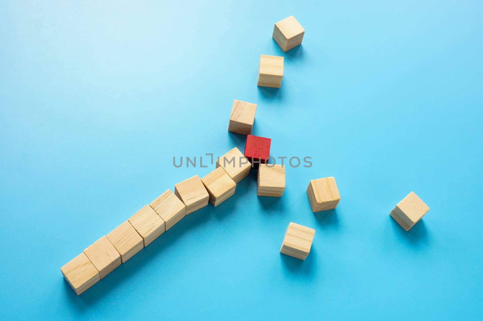 The line of wooden cubes breaks up due to an obstacle or problem.