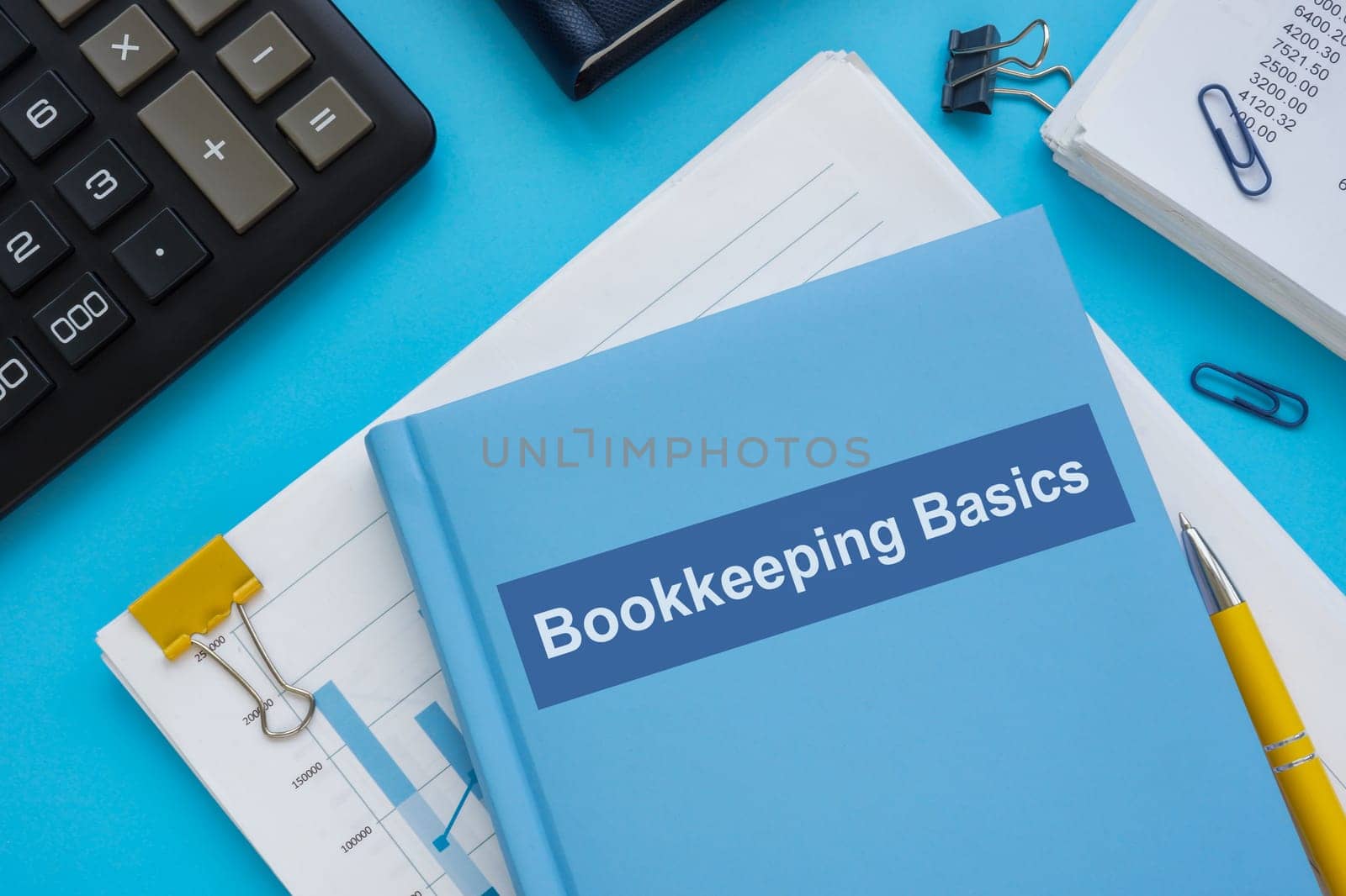 Bookkeeping basics books on the stack of papers.
