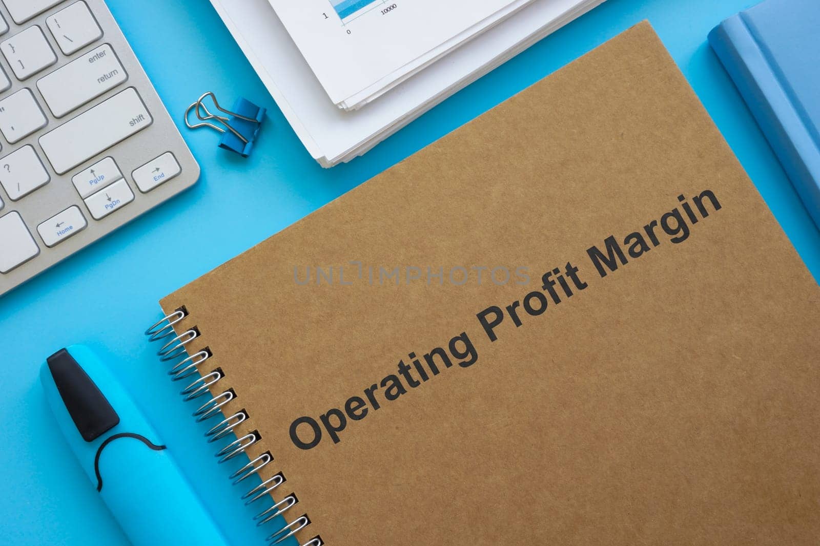 Operating profit margin documents, papers and a marker.