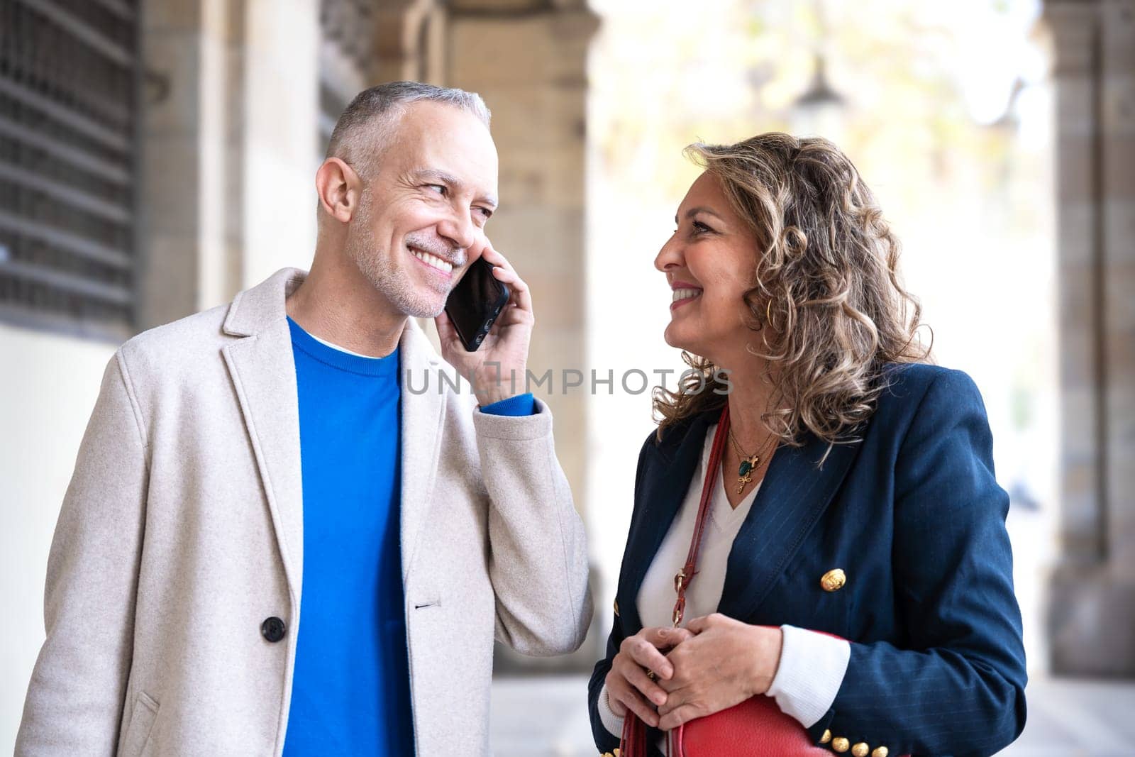 Happy friends or couples talking on smartphone outdoors. by mariaphoto3