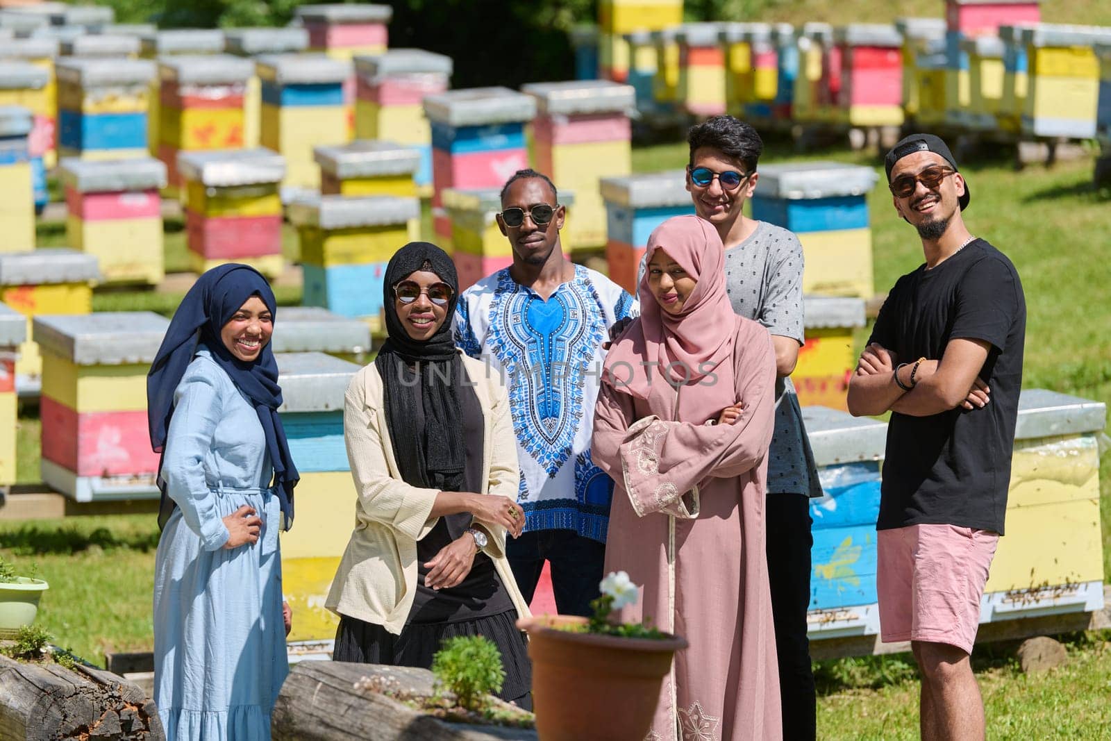 A diverse group of young friends and entrepreneurs explore small honey production businesses in the natural setting of the countryside