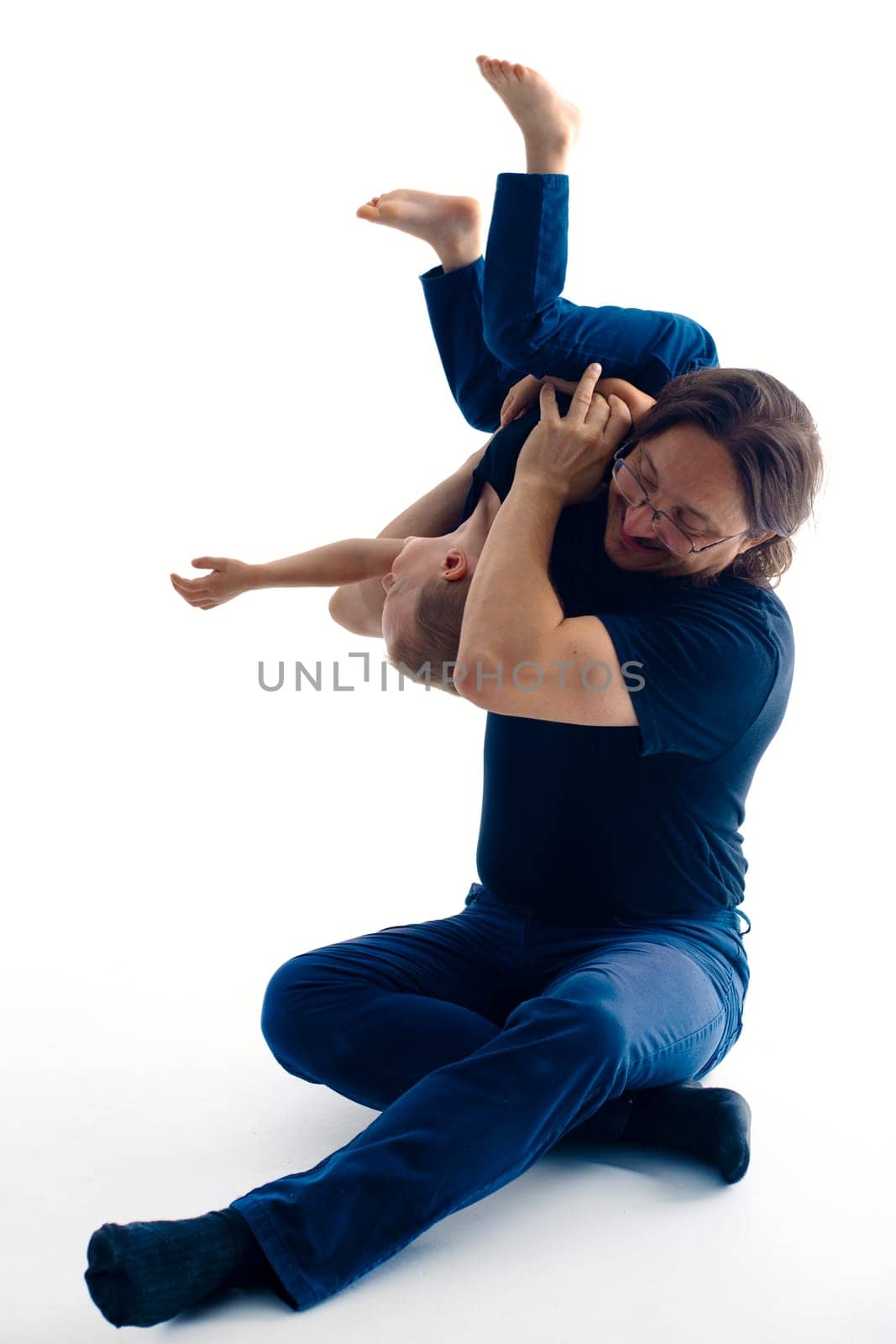 young handsome father with his son fooling around, lifestyle on white background. High quality photo