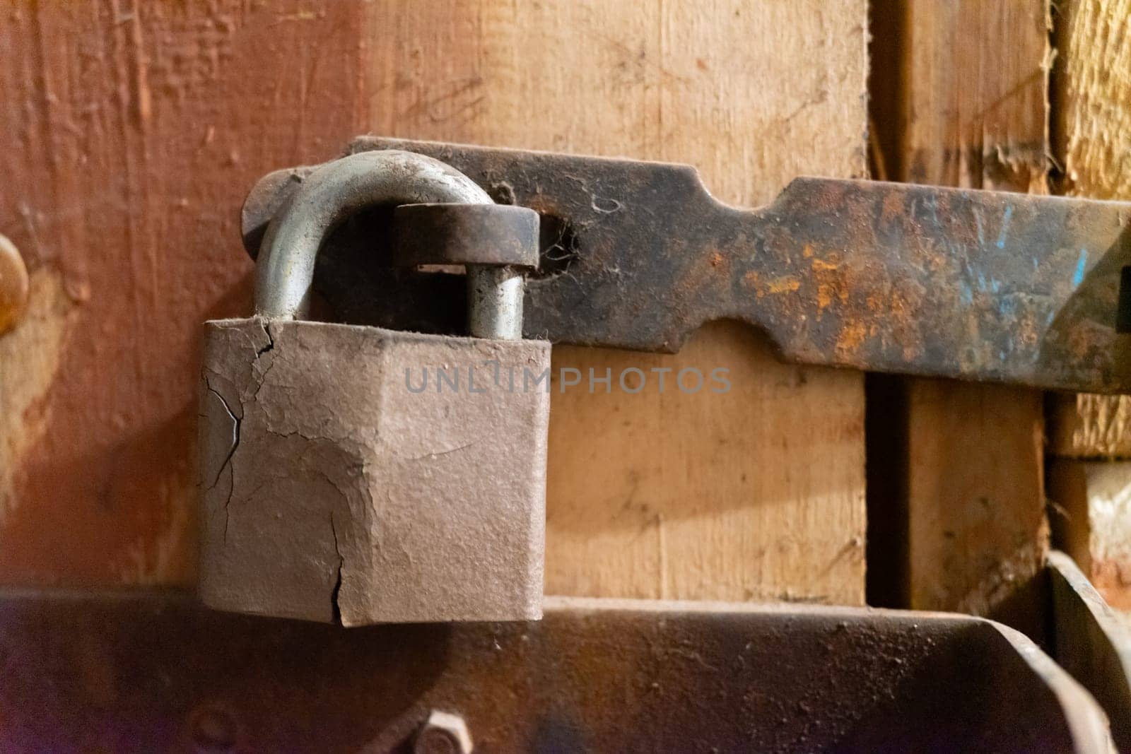 Old cracked lock on a wooden door.