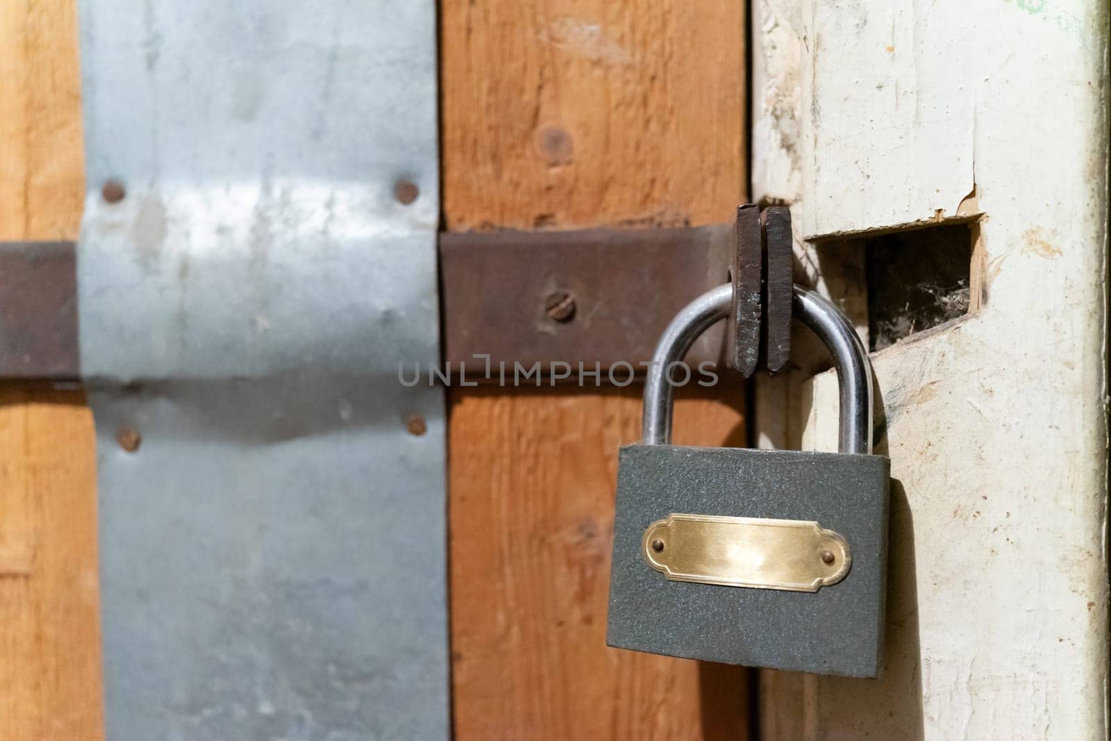 A closed wooden door with a small metal lock.