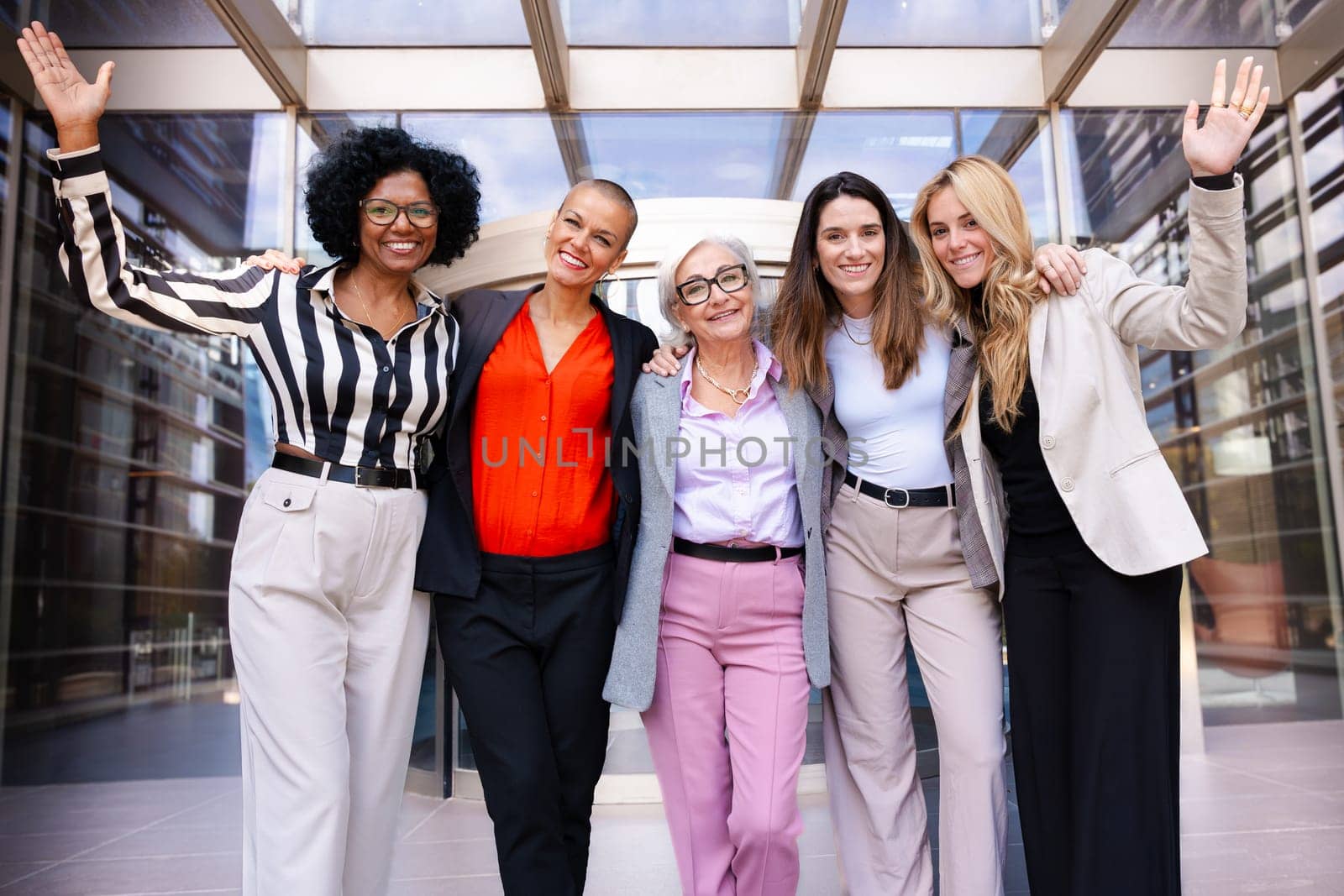 Multiracial businesswomen led by boss posing happy for the camera. by mariaphoto3