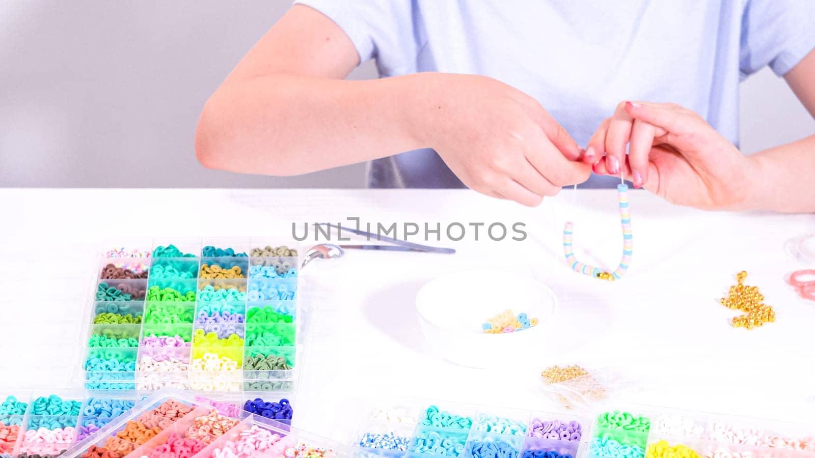 Little Girl’s Adventure in Bracelet Making with a Rainbow of Beads by arinahabich