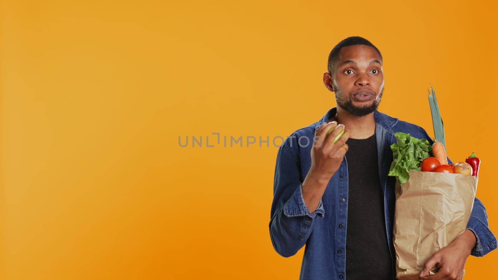 Confident man juggling with an eco friendly green apple on camera by DCStudio