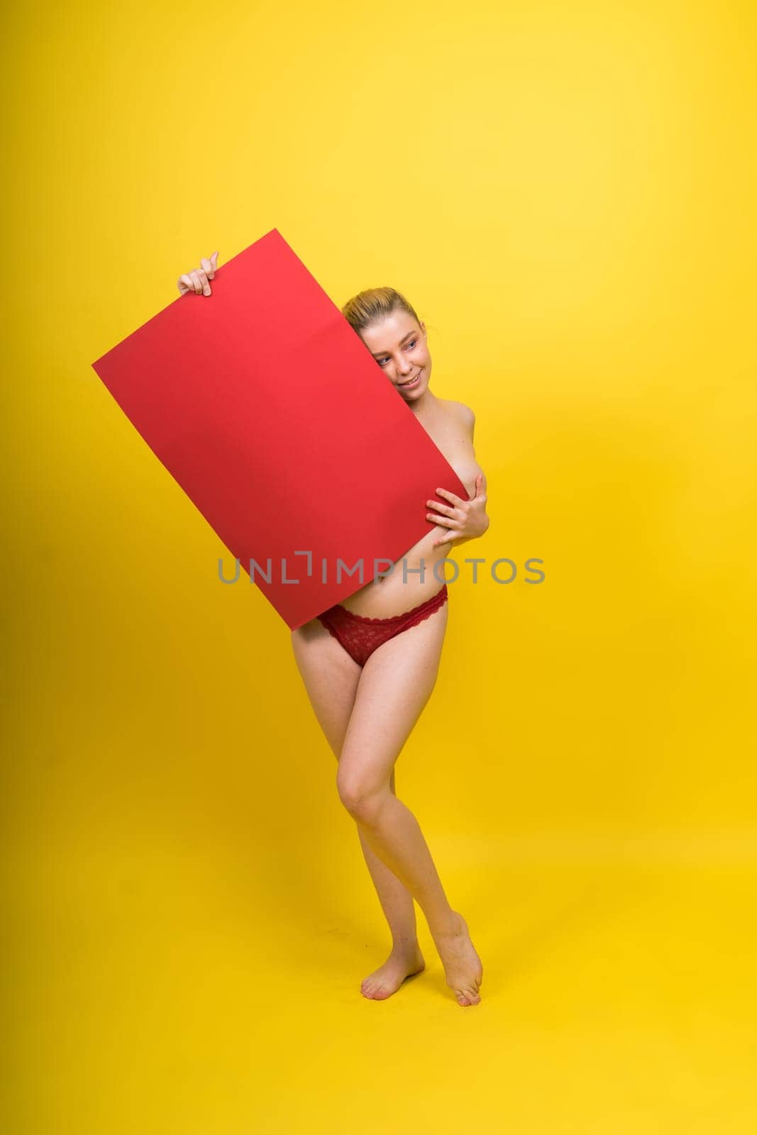 Blonde model, Young woman holding a cardboard cloud red sheet of papaer, place for an inscription