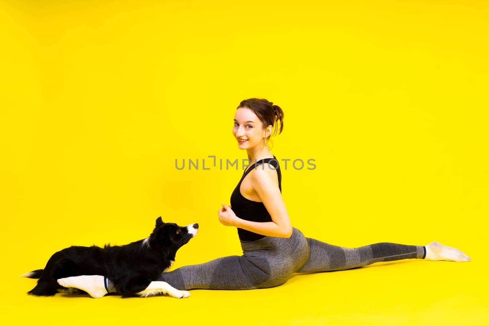 A beautiful sport female with border collie in a studio