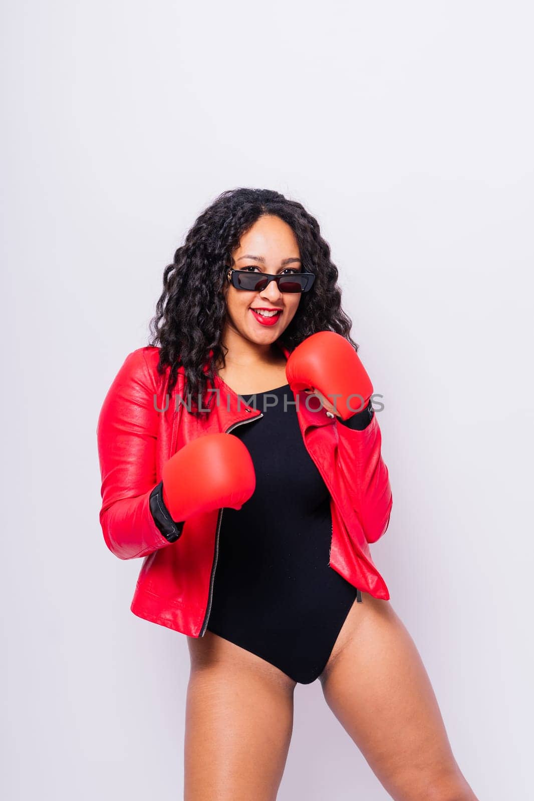 A beautiful young woman wearing pair of boxing gloves