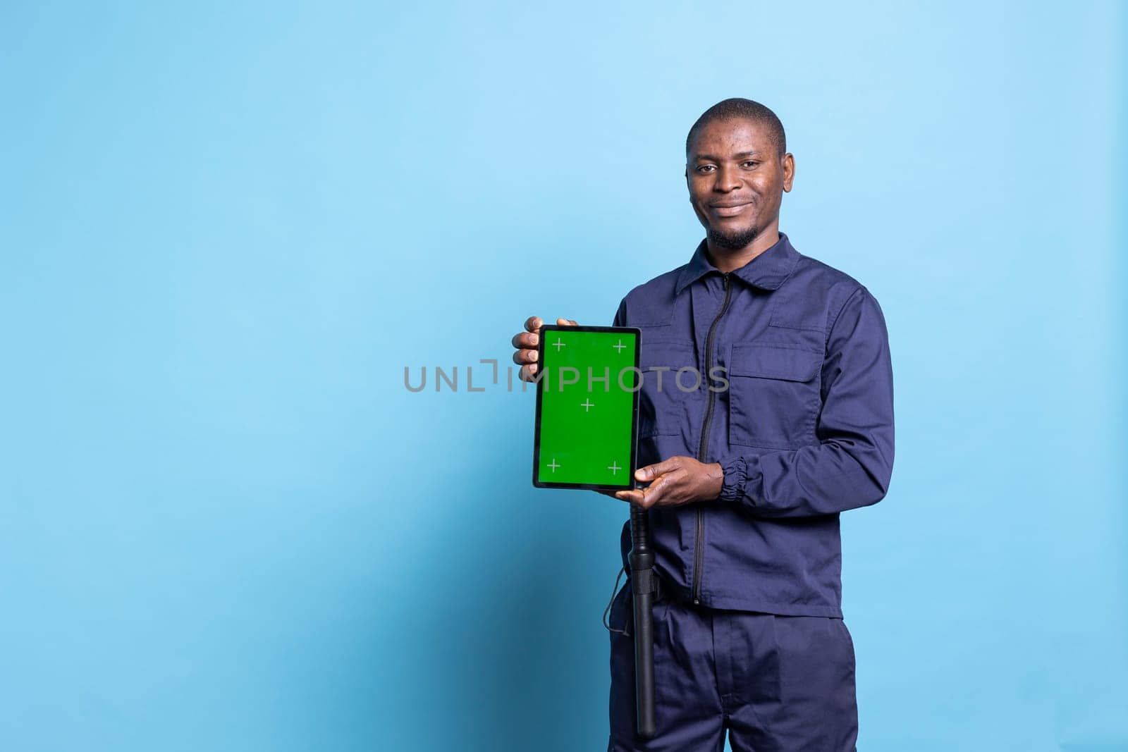 Security officer holding a device with greenscreen display in studio by DCStudio