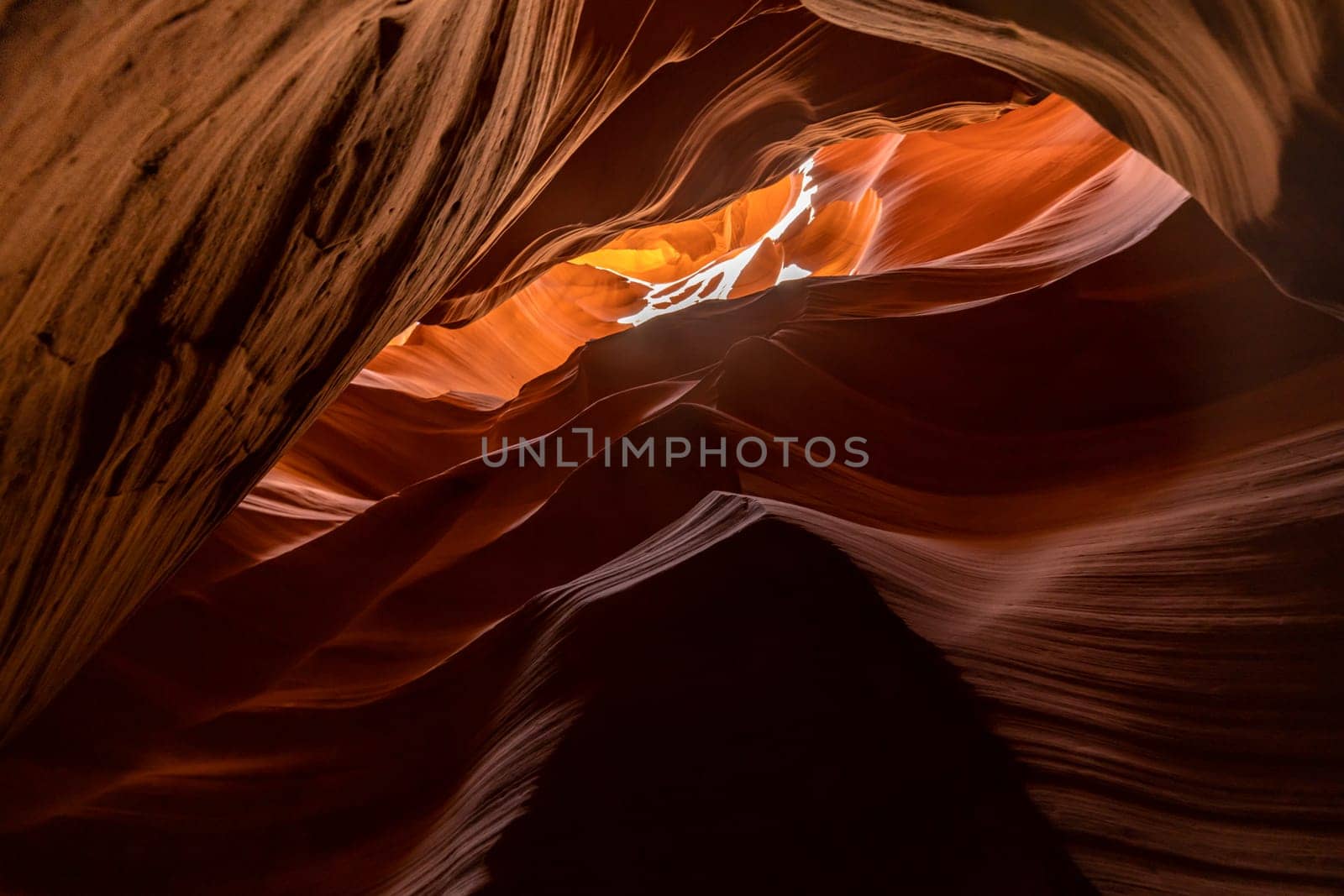 Famous, iconic, slot canyon captured in midday sun with bright orange and dark shadows in the sandstone, geological structure near page, arizona, usa