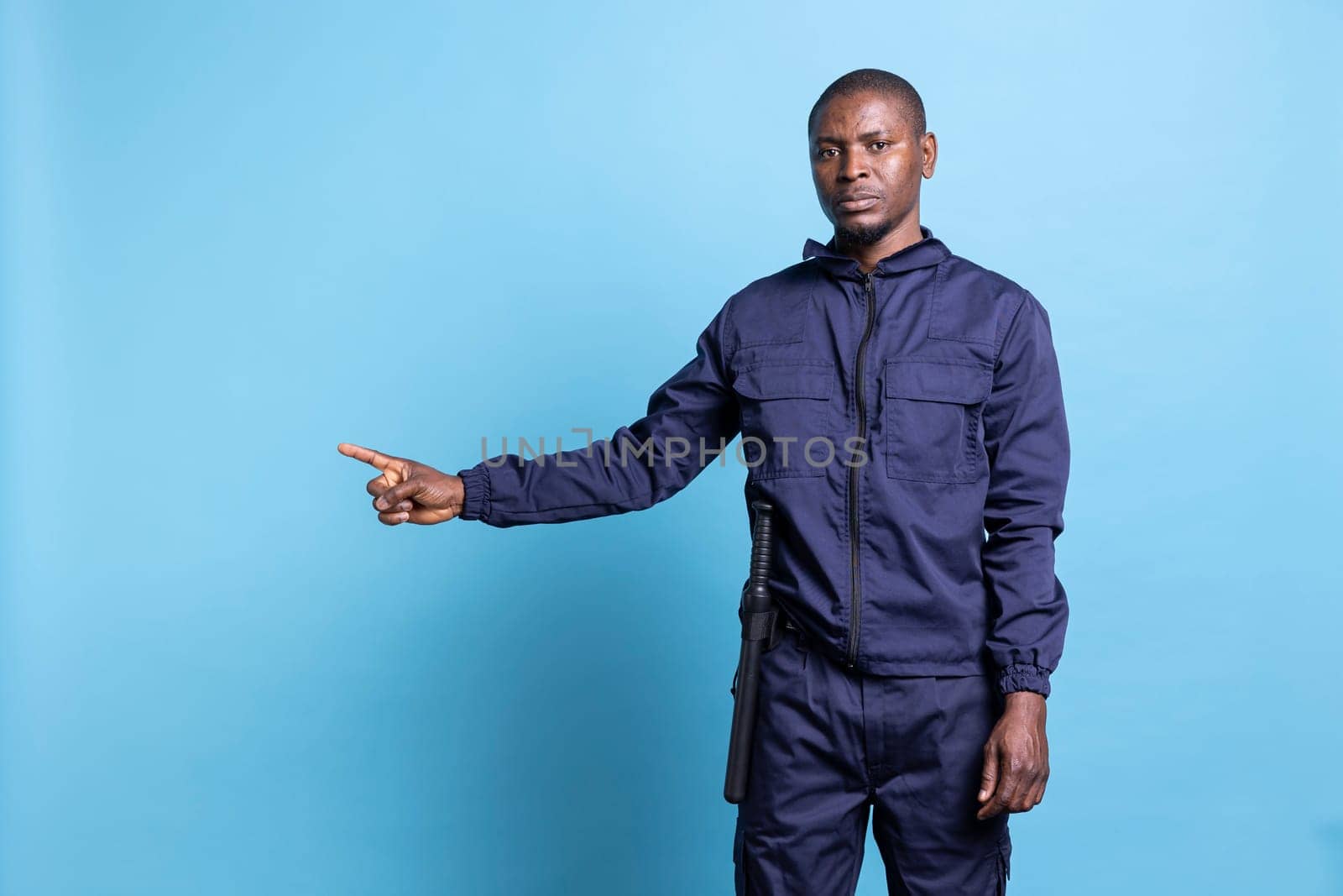 African american bodyguard pointing to something aside in studio by DCStudio