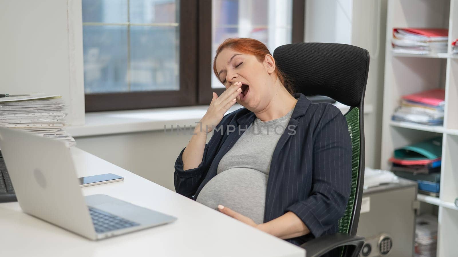 Pregnant woman sleeping at her desk in the office. by mrwed54