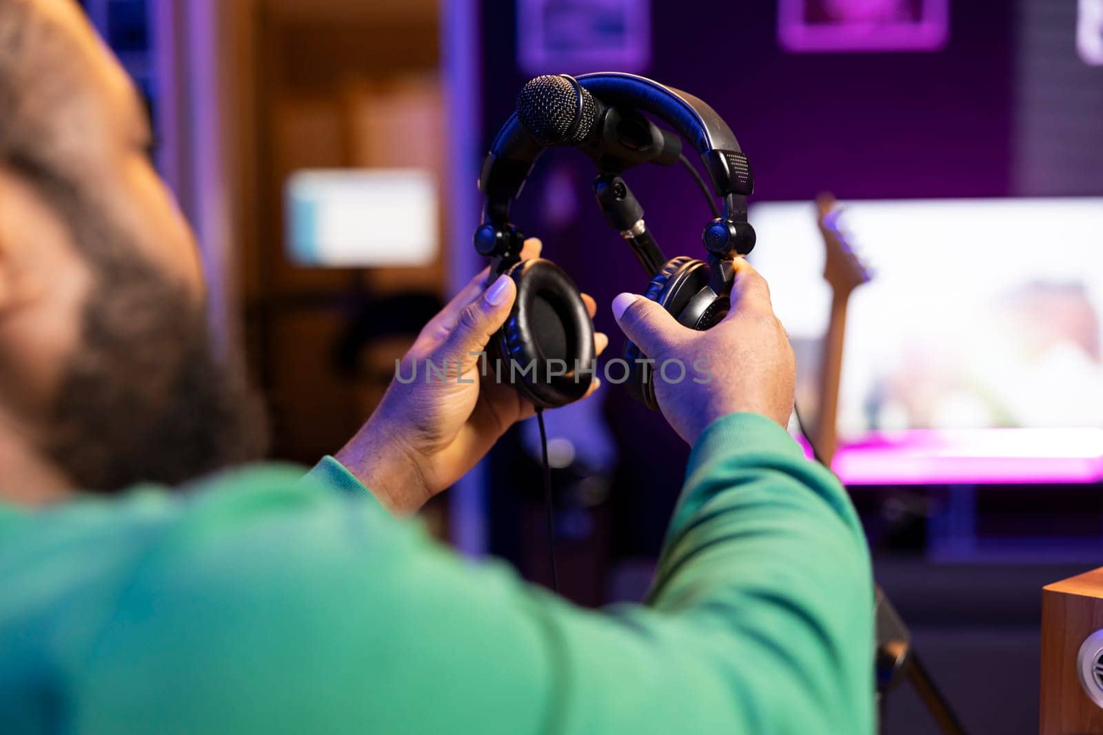 Professional sound engineer picking up his headphones for a recording session by DCStudio