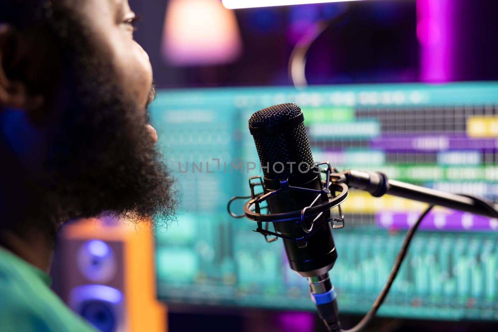 Male composer recording his melody on microphone in home studio by DCStudio