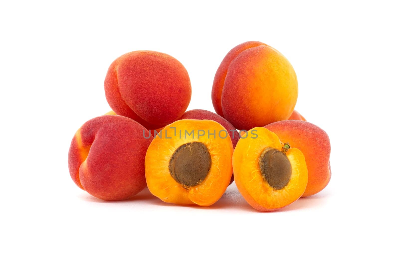 Collection of ripe whole apricots and one cut in half to reveal its interior, isolated on a white background
