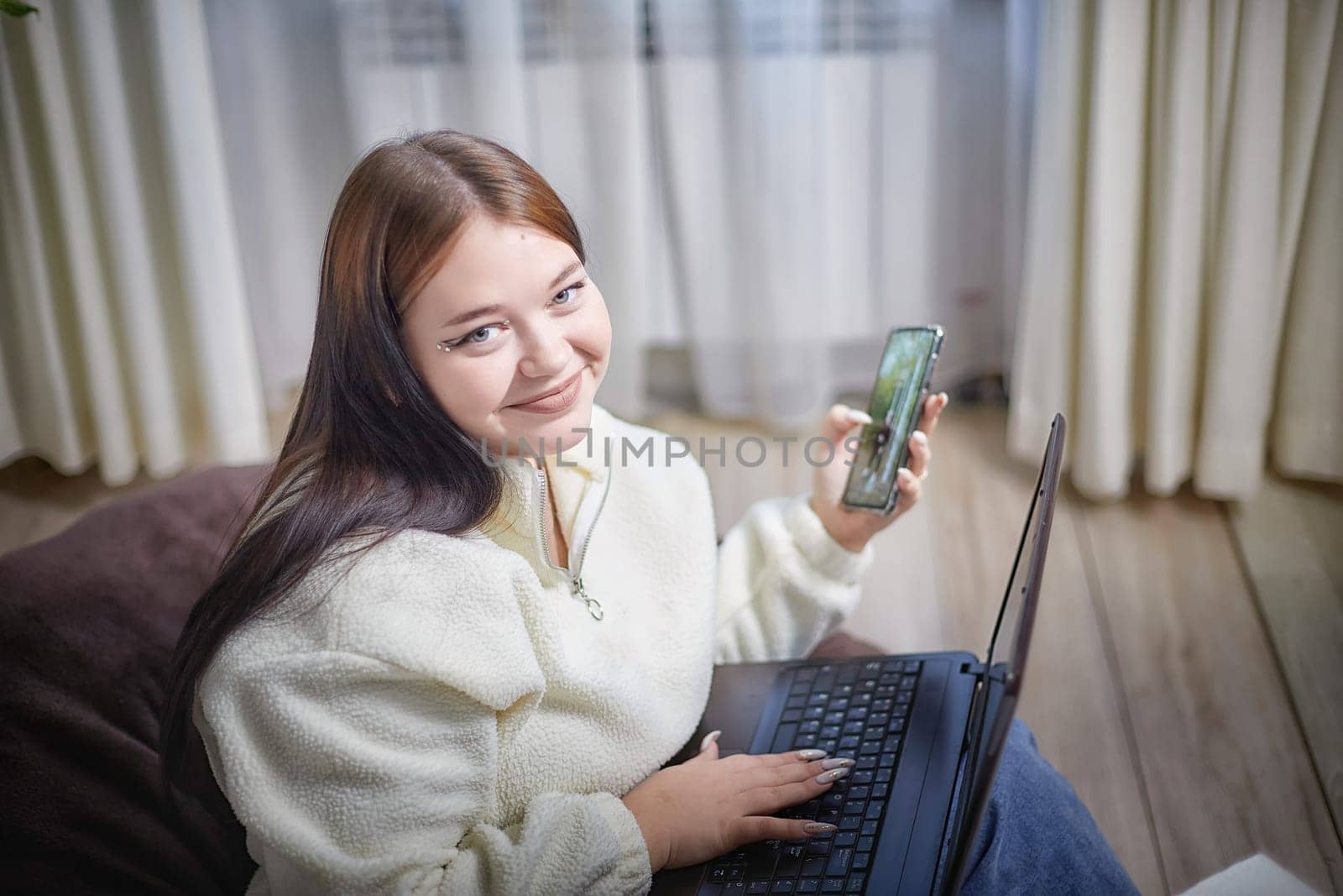 Fashionable young overweight plump female freelancer with portable computer, typing, working remotely from home. Brunette plus size girl using laptop