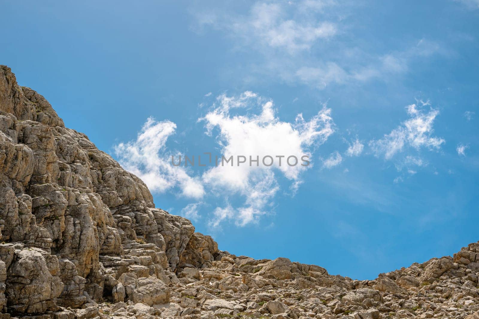 Rocky hill with clouds visible in the background on a sunny day