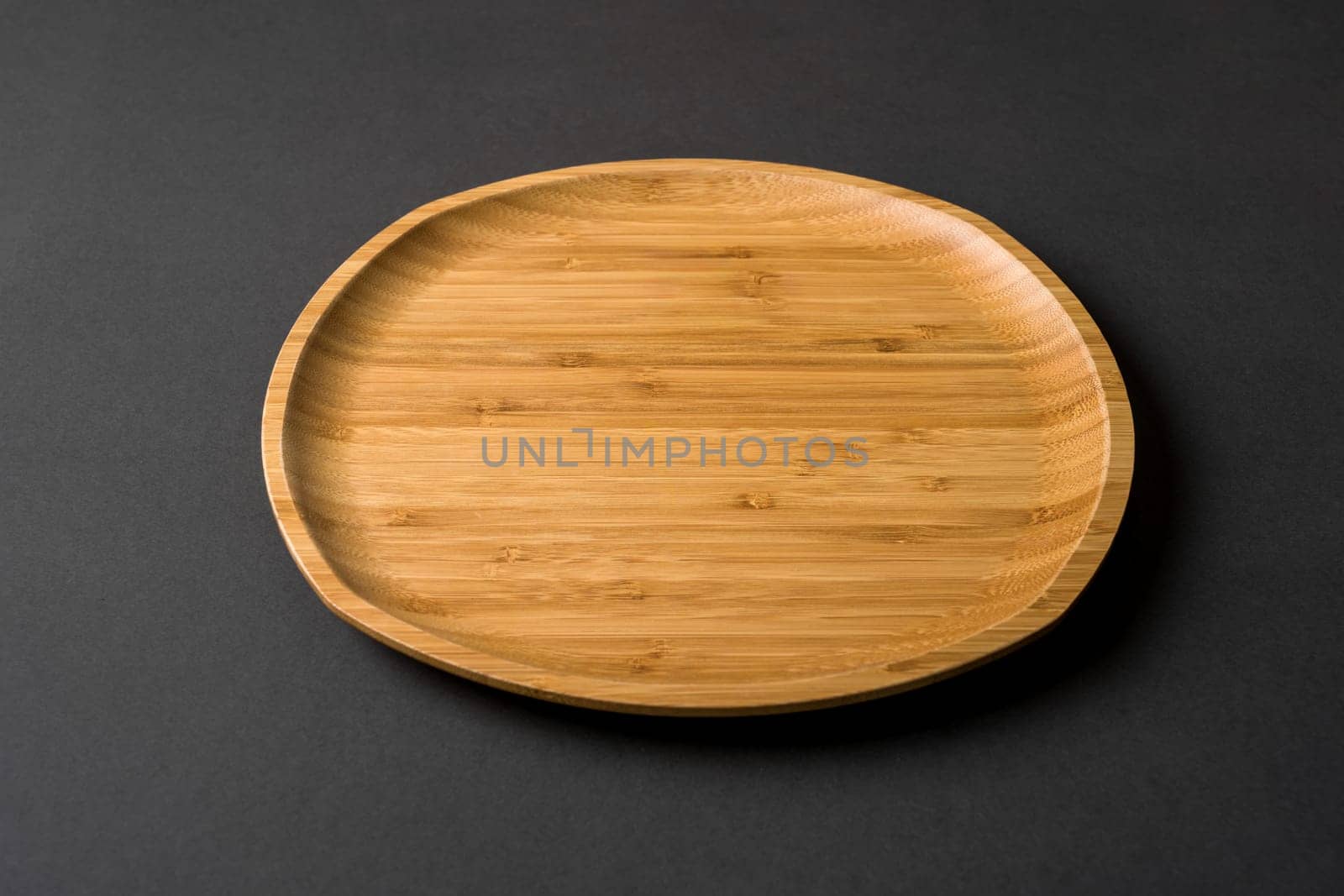 Wooden plate on dark gray background. handmade kitchen utensils
