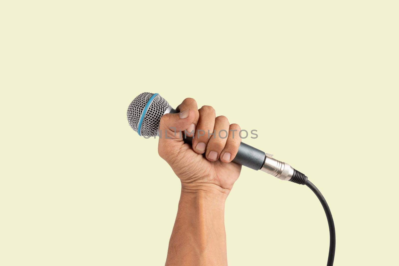 Black male hand holding a microphone isolated on green background. High quality photo