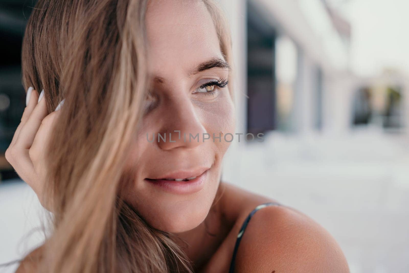 Happy woman portrait in cafe. Boho chic fashion style. Outdoor photo of young happy woman with long hair, sunny weather outdoors sitting in modern cafe