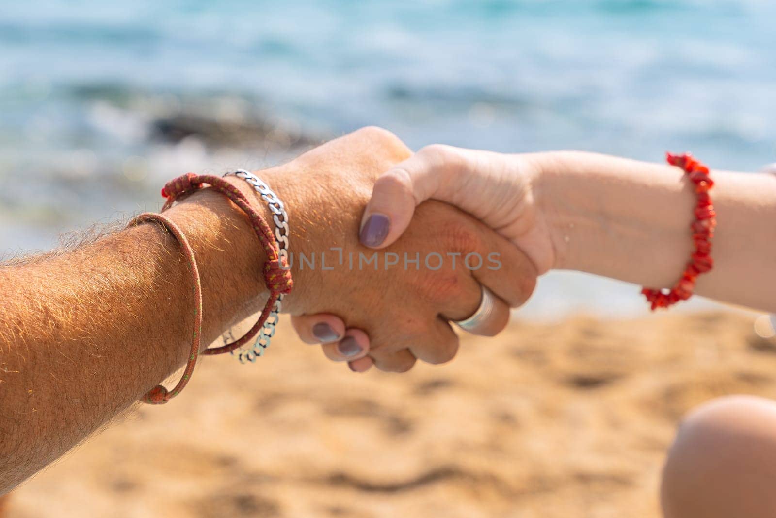 Unrecognizable friends high-fiving on the beach by mariaphoto3