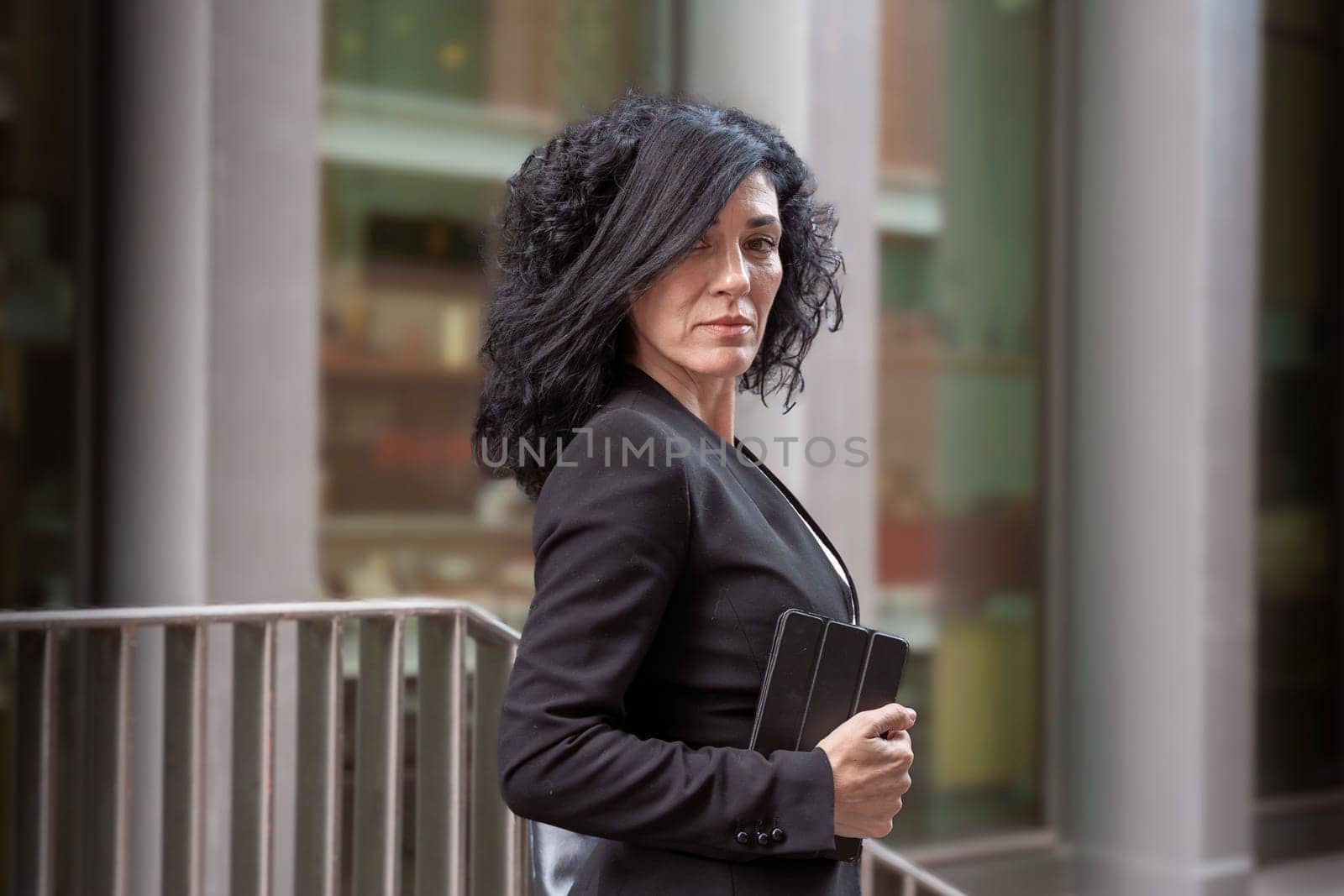 Middle Aged Caucasian Business Woman, Serious Standing With Digital Tablet In Hands Looking At Camera