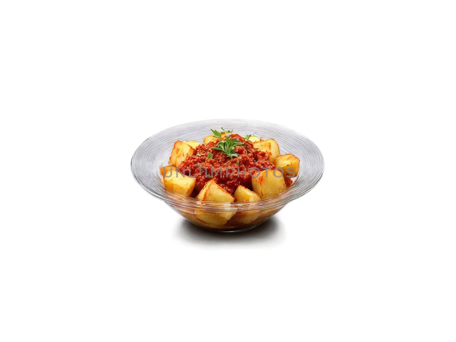 Tapas patatas bravas with spicy tomato sauce and aioli served in a transparent glass bowl. Food isolated on transparent background.