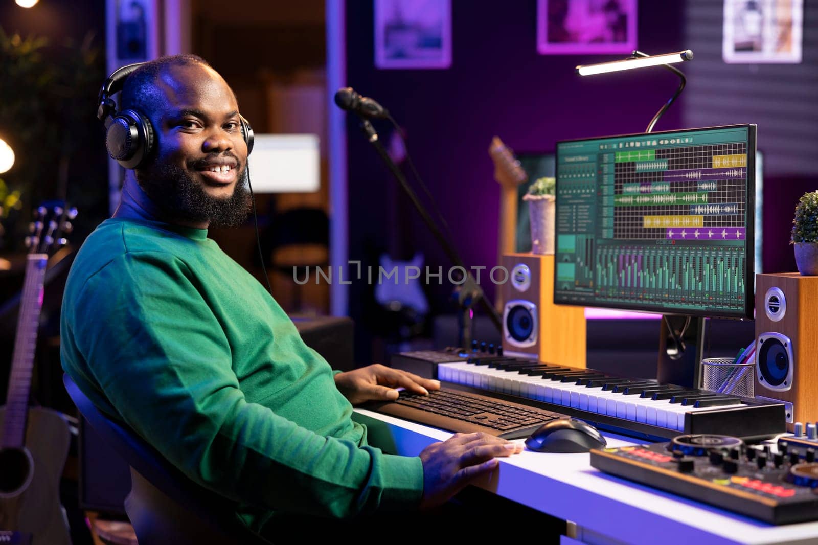 Portrait of sound engineer working on producing music in home studio by DCStudio