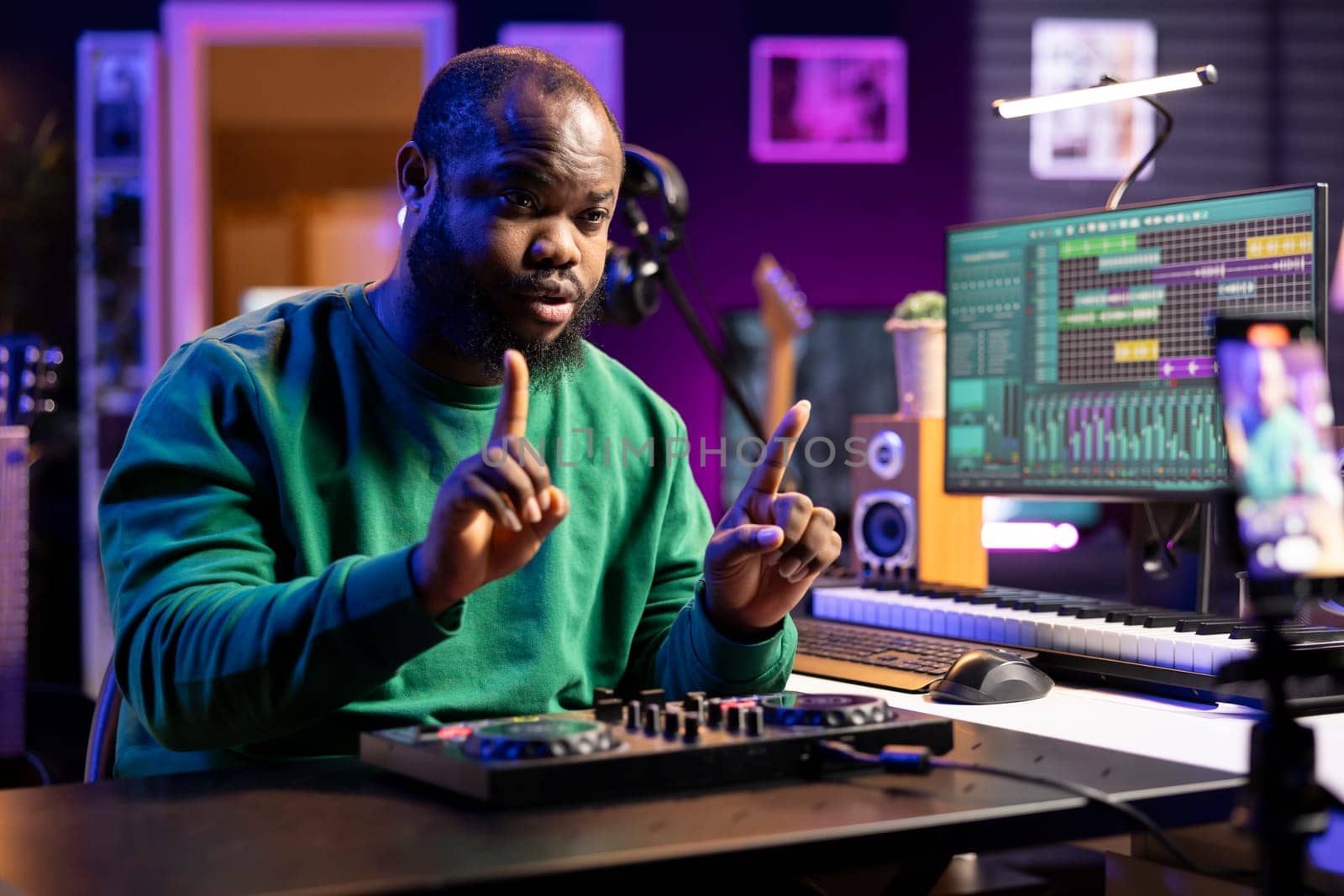 Young producer teaching people to use a mixing console during online lessons by DCStudio