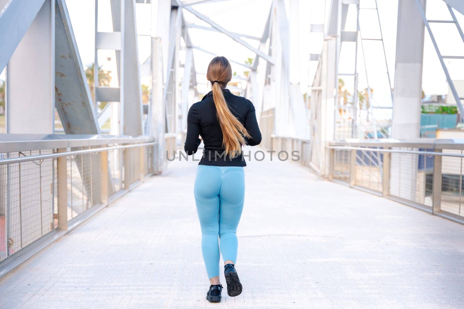 Fitness girl is running outdoors. Concept of workouts and healthy lifestyle.