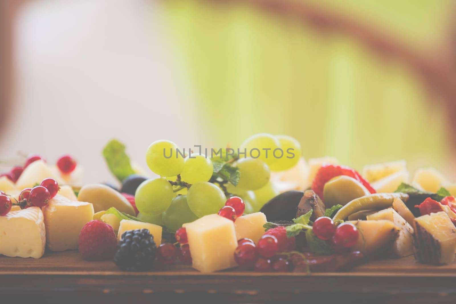 Cheese plate with berries. delicious appetizer for aperitif, copy space outdoor.