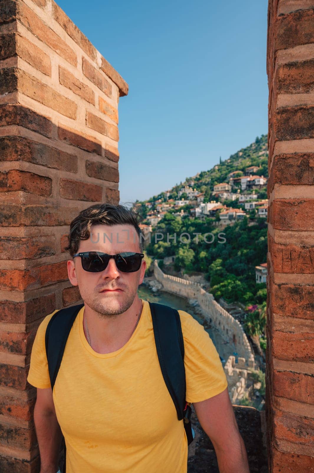 Man at fortress ruins of the historical Red Tower - Kizil Kule, in Alanya Castle, the famous touristic place.