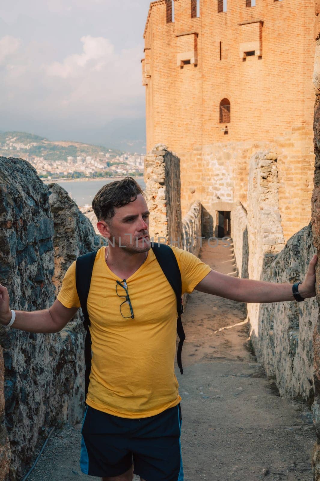 Man at fortress ruins of the historical Red Tower - Kizil Kule, in Alanya Castle, the famous touristic place.