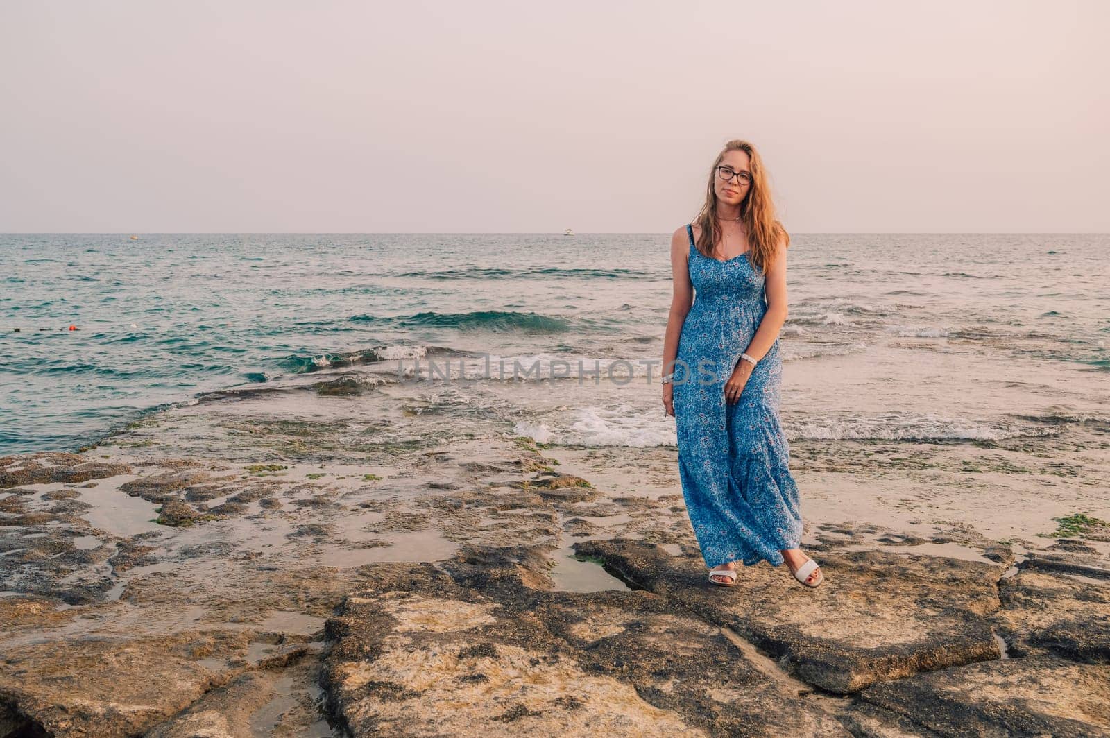 Woman sits on the beach and looks at the sea in Alanya city, Turkey. Travelling or vacation concept