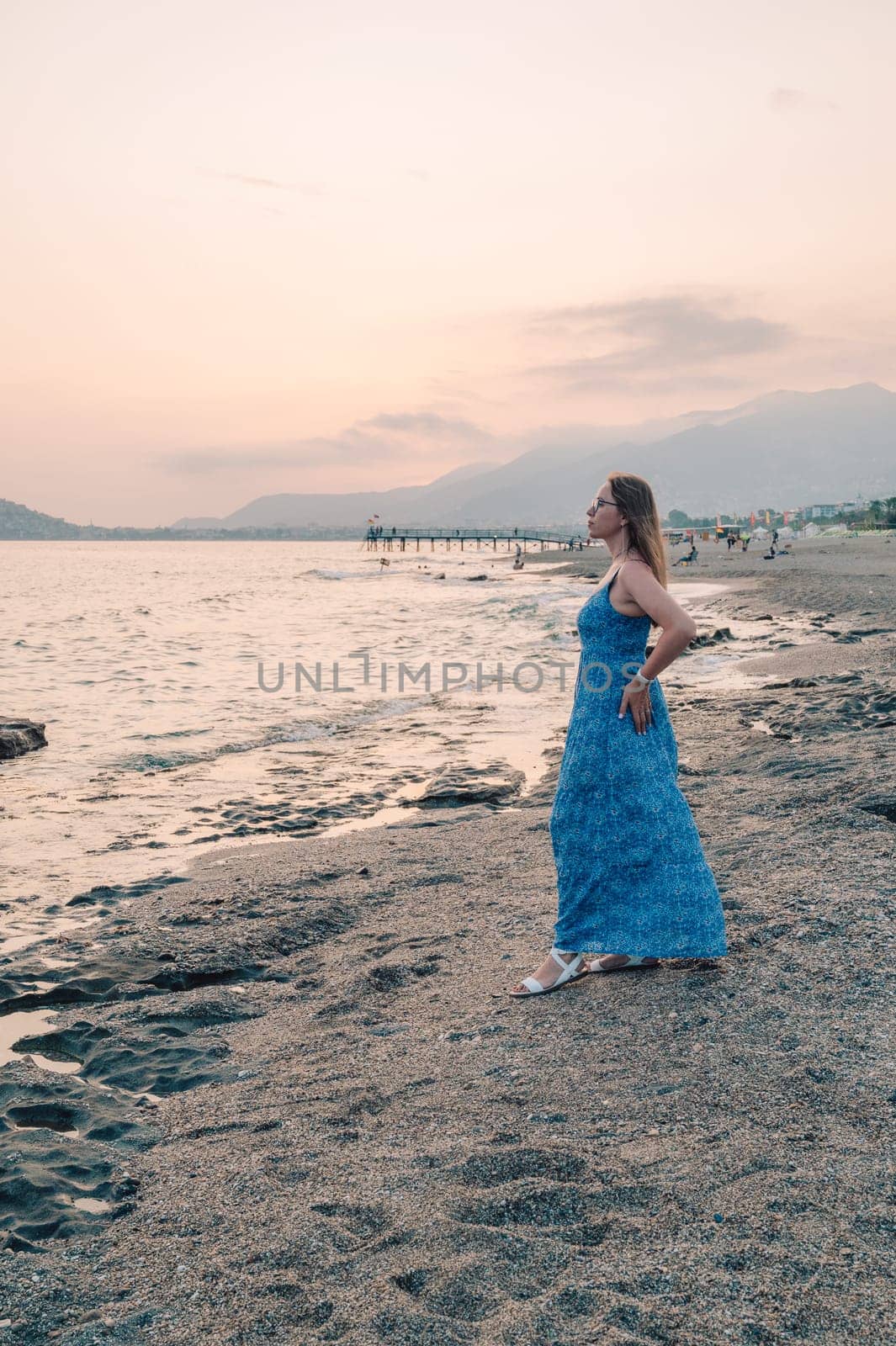 Woman sits on the beach and looks at the sea in Alanya city, Turkey. Travelling or vacation concept