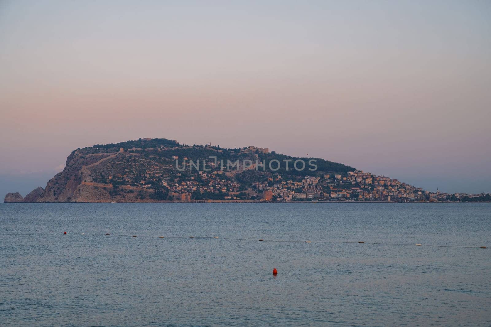 Beautiful sunrise scene on Alanya beach with view to famous Alanya island, in Turkey