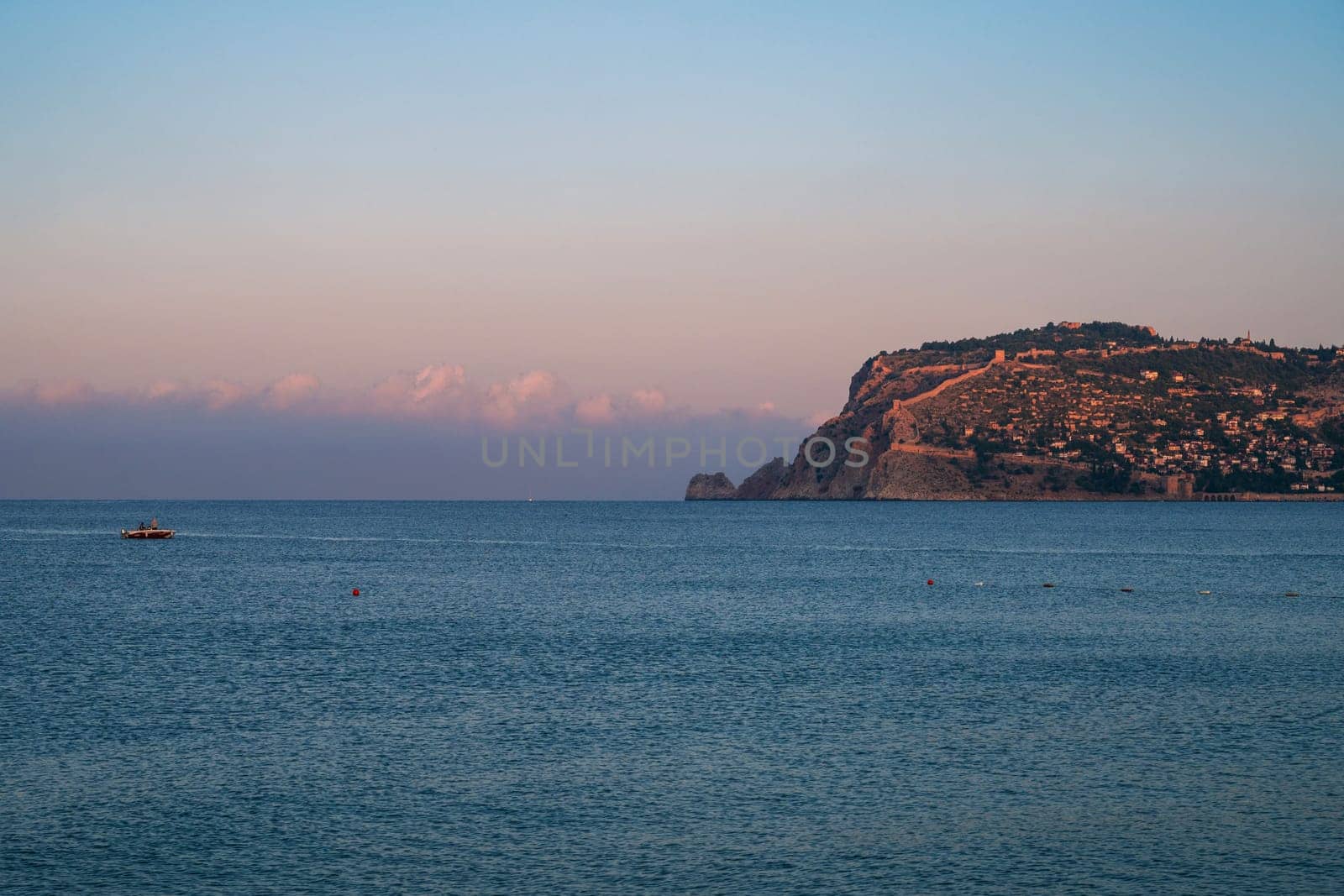 Beautiful sunrise scene on Alanya beach with view to famous Alanya island, in Turkey