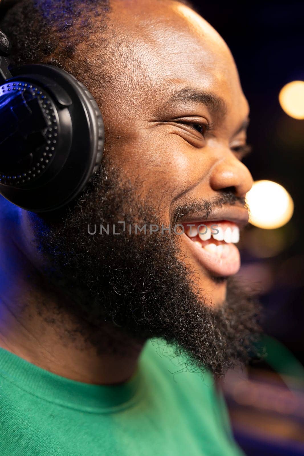 Enthusiastic sound engineer feeling joyful creating new music, doing what he loves in his home studio. Happy young producer smiling after hearing his finished track recorded and edited. Close up.