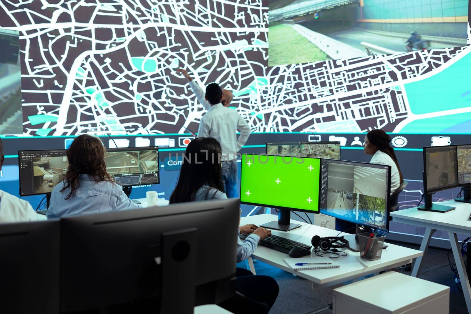 Indian woman dispatcher works with isolated copyspace on screen next to real time surveillance footage, transmitting gps coordinates to the drivers. Employee uses satellite navigation.