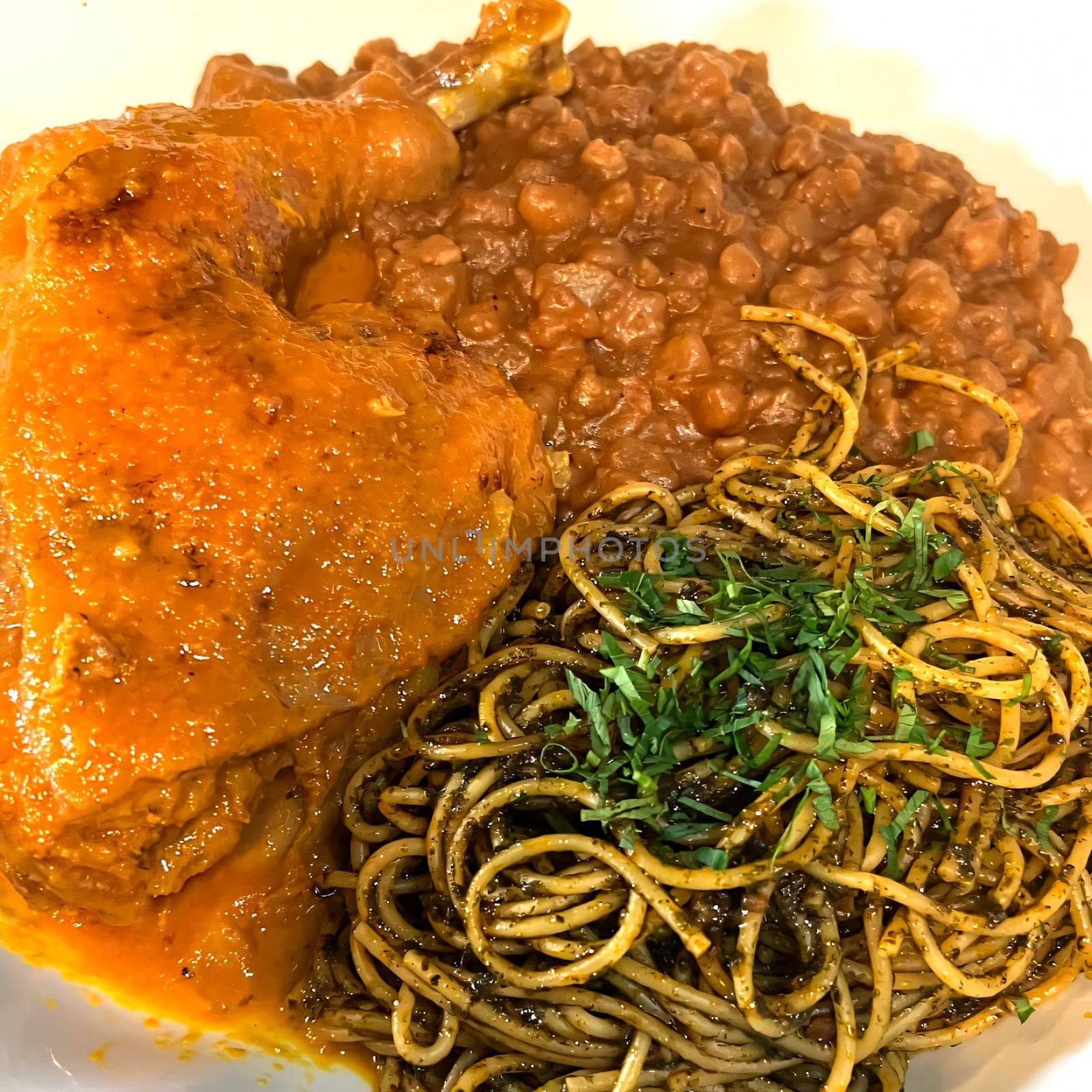Close-up of a classic mexican dish featuring mole poblano, savory refried beans, and herb-infused green spaghetti