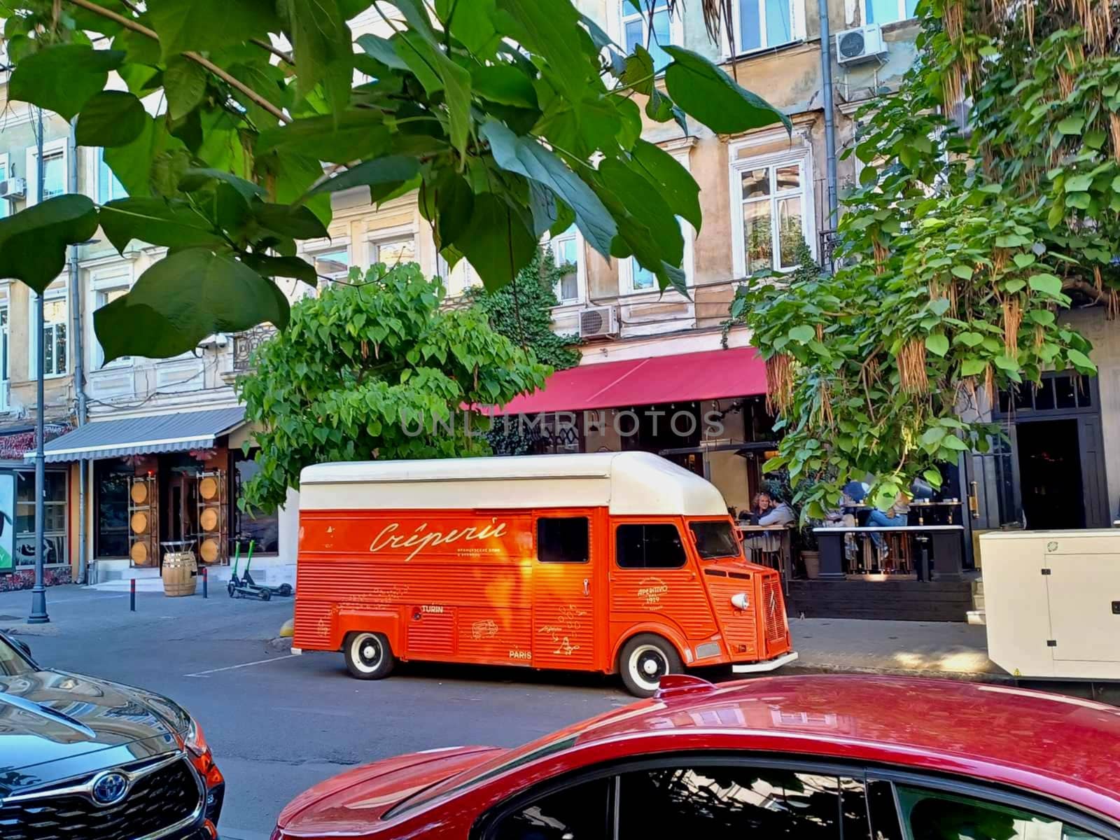 Odessa.Odessa.Ukraine - 06.04.2024: Along Odesskaya Street at Ekaterininskaya Street No. 6. There is an orange caravan with an advertisement for a restaurant on the roadway.