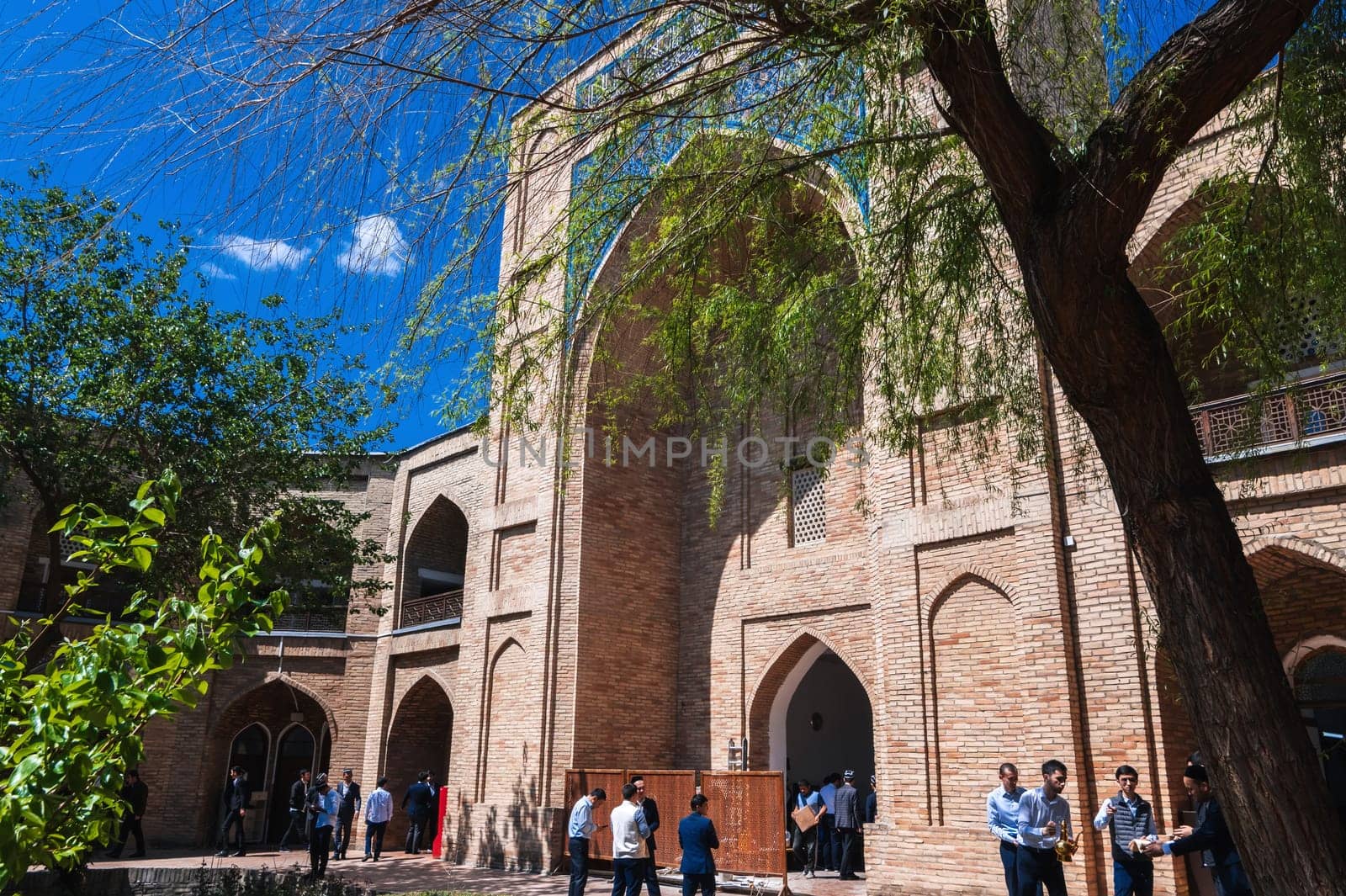 Students in the courtyard of ancient Islamic educational Kukeldash Madrasah. Tashkent, Uzbekistan - April 17, 2024