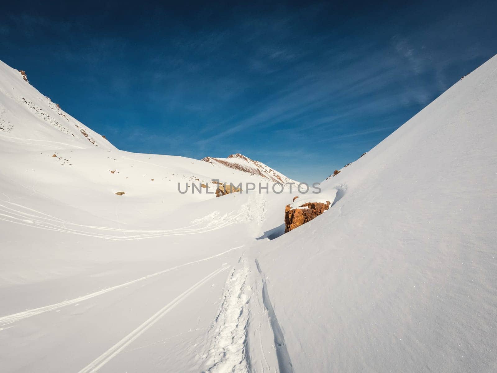 Mountain hilly winter landscape with traces of hiking trails and skis. snowy desert.