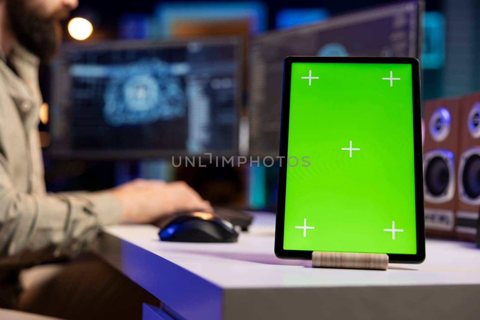 IT expert scripting artificial intelligence on computer with green screen tablet on desk next to it. Programmer working on coding AI on desktop PC with chroma key device near