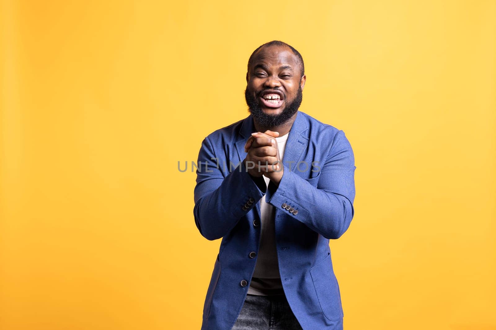 Portrait of overjoyed african american man laughing hard, amused by funny joke, studio background. Happy BIPOC person chuckling and giggling, delighted by comedian, feeling entertained