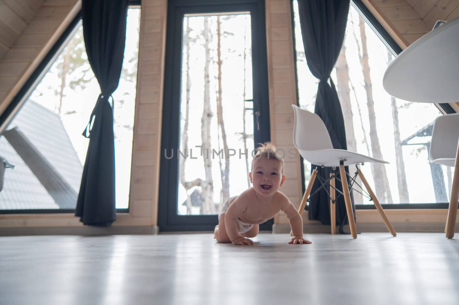 Little boy crawling on the floor by the patio window